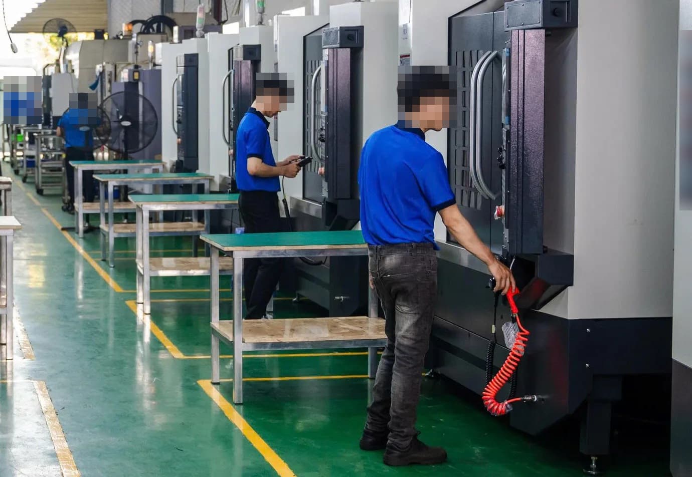 CNC production aisle with operators at machining centres